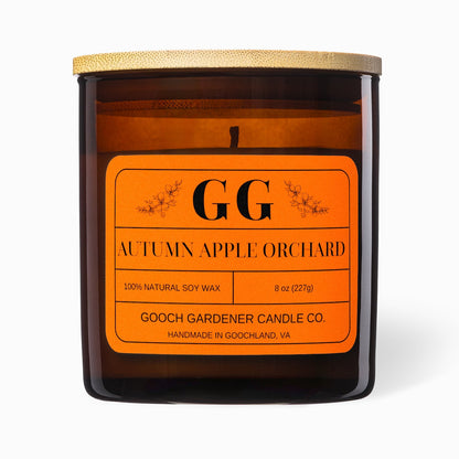 Candle with orange label featuring 'GG' branding on a white background