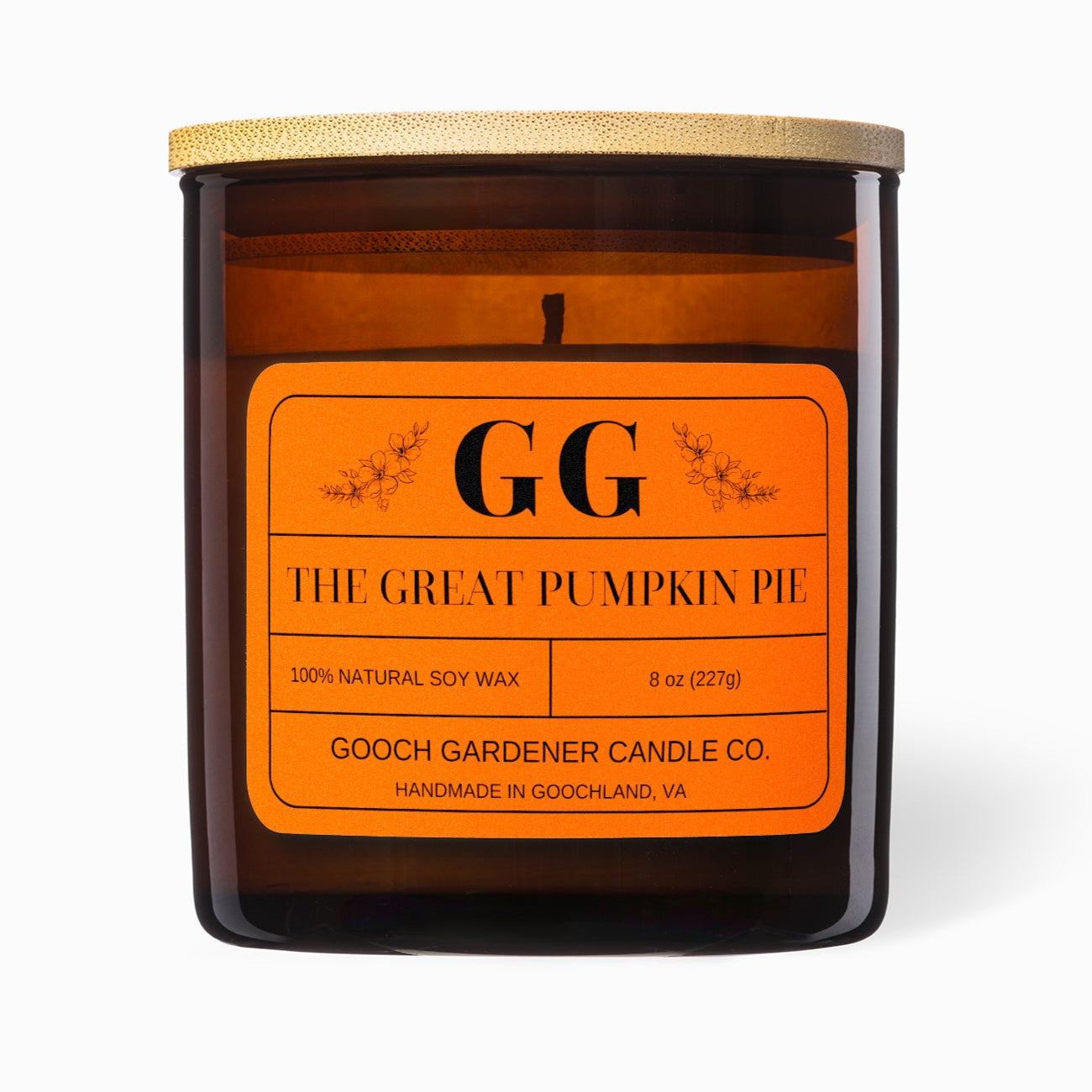 Candle with orange label featuring 'GG' on a white background